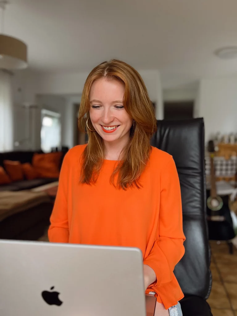 Leonie Connects - smiling at her laptop on her lap